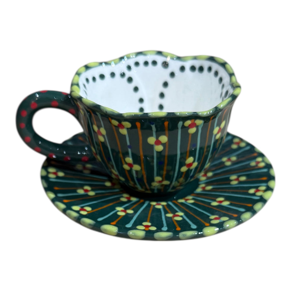 Polka dot teacup and saucer with orange, blue, and green pattern on a white background